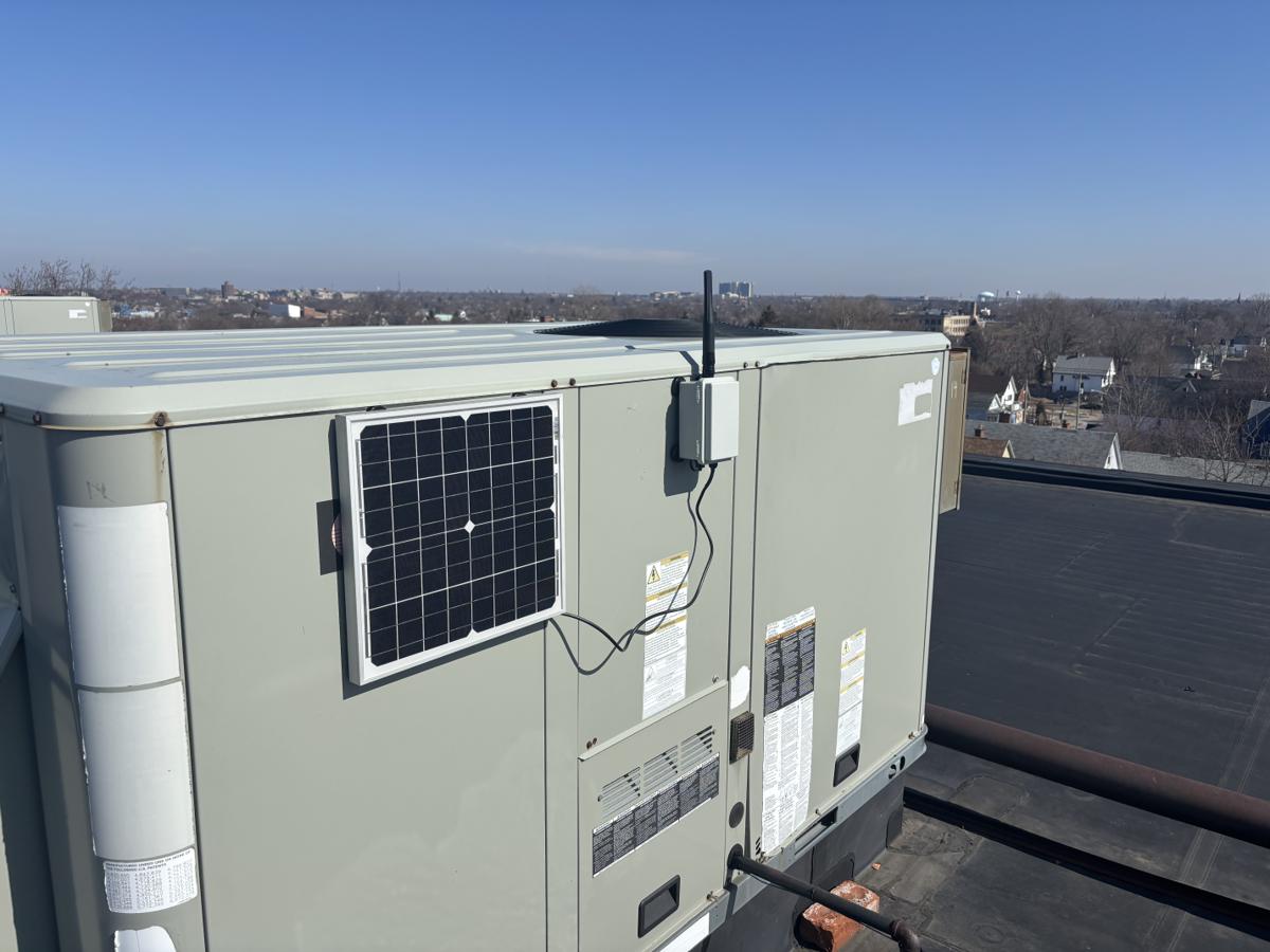 Solar-powered MeshCore repeater node installed on a commercial rooftop in Western NY